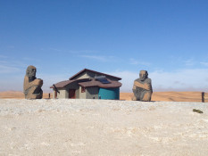 While surrounded by ultra-modern, colorful, and unique architecture, the Desert Breeze Lodge buildings contrast sharply with the surrounding desert landscape. In this photo, see enormous basalt sculptures standing on guard over this interesting desert destination.