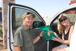 Dave and Catherine visited the Erongo Wilderness Lodge. Their guide, Richard zu Bendheim, hands a present to Catherine in this photo.