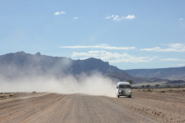 Observe the speed limit when driving in Namibia: 120km/h on tarred roads, 80km/h on gravel. 

Take special care on gravel, which can be deceptively tricky. For example, braking suddenly may turn your vehicle over, while you need to slow right down at Turn on headlights on gravel roads. 

When overtaking (passing) on gravel, be aware your plume of dust can obscure the vision of the overtaken driver.