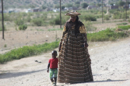 The Herero (together with the Himba) moved into present-day Namibia and Botswana several hundred years ago. 

During the 19th century, the Herero came under the influence of German missionaries who took exception to what they considered to be the immodesty of the traditional Herero dress, or lack of dress (similar to the Himba). Herero women eventually adopted the style of dress that makes them so distinctive today. Although the influence of the missionaries is certainly diminished in modern day Namibia, Herero women are still seen proudly wearing this elaborate costume in rural parts of the country as well as downtown Windhoek. Herero men cannot be distinguished by clothing except on special occasions. Then Herero men wear an elaborate suit that is reminiscent of 19th century German military uniforms.
