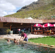 The Calabash is a nearby open air "bushpub", quite popular with both local farming families on weekends as well as visitors from Cape Town touring the Winelands and crossing the historic Bainskloof Pass just to the west. In this photo, see parents drinking local wines and eating a Sunday brunch while the youngsters frolic in the swimming pool under watchful eyes. English and Afrikaans is spoken interchangeably by most. Built as a cattle shed in 1899 at the Eastern base of the winding Bainskloof Pass, it is now owned and operated by Willie Lategan. If you are up for a good time, don't miss it.