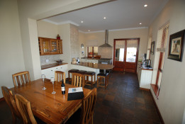 Here is a photo of the dining area and kitchen which are both very light and bright.