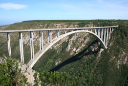 Completed in 1983 and at 216 meters, Blaukrans is the highest road bridge in Southern Hemisphere and the third highest bridge in the world. It is also the largest single span concrete arch bridge in the world! Everyone who drives the N-2 highway from Mossel Bay to Port Elizabeth (the "Garden Route") crosses this magnificent structure. On the Eastern side, there is a Bridge Building Museum and outlook point. If you like, there is a catwalk attached to the underside of the bridge (on the seaward side) leading to the top of the arch, the location of a remarkable commercial enterprise: bungy jumping.