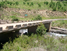 Pictured is the bridge over the Delmhwazine River which is in the Drakensberg Mountains. The Drakensberg Mountains are part of the continuous escarpment that rings the high center plateau of South Africa. These are serious mountains that kept most Dutch settlers on the coastal plain until the early 1800's. In November 2000, the 243,000 hectare Drakensberg Park received the World Heritage Site status, the fourth such in South Africa. It is a beautiful place to visit and not-to-be-missed on your South African adventure.