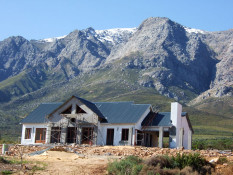 Construction of our Kingsbury Cottage continued throughout 2007 even into the wet South African winter. The winter rains had slowed construction somewhat but the guest cottage was closing in on completion. The site had also been filled and graded to nearly level in front of the cottage, but the final landscaping would wait until summer, 2008. In the Western Cape, winter is much akin to Northern California- heavy rains for a few days, and then spectacular blue skies. On this day, the snows in the mountains to the east are apparent and our reservoirs are as full as we want them from storm runoff.
